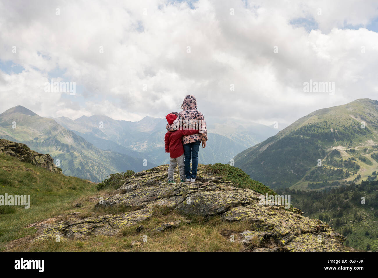 Andorra, Ordino, giovane ragazza e suo fratello il braccio intorno, in piedi sul punto di osservazione in montagna Foto Stock