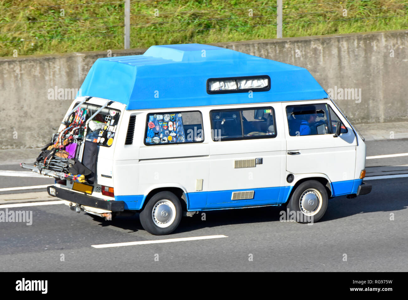 Laterale e posteriore della VW blue & white hi-top transporter camper & driver modificato bike rack per camping sundries esposto sul retro del veicolo autostrada del Regno Unito Foto Stock