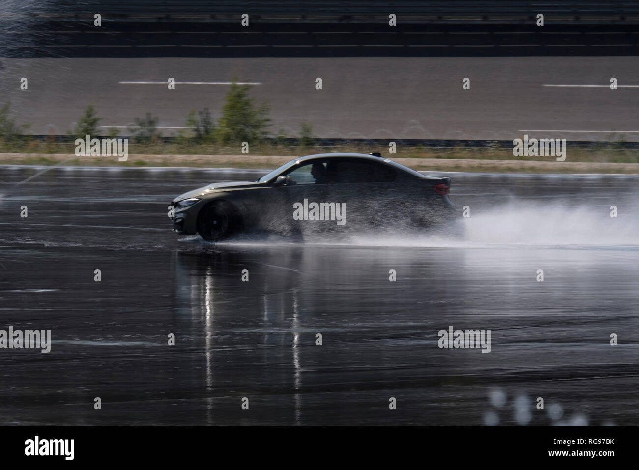 Guida auto sulla superficie umida sulla pista Foto Stock