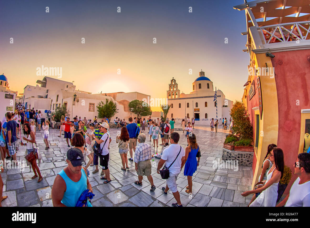 Fantastici panorami dal villaggio di Oia a Santorini Island. Tramonto idilliaco con turisti e visitatori di camminare lungo le tradizionali case greche a Oia Foto Stock