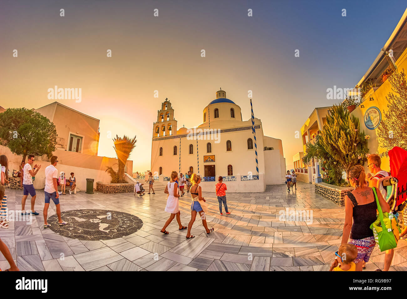 Fantastici panorami dal villaggio di Oia a Santorini Island. Tramonto idilliaco con turisti e visitatori di camminare lungo le tradizionali case greche a Oia Foto Stock