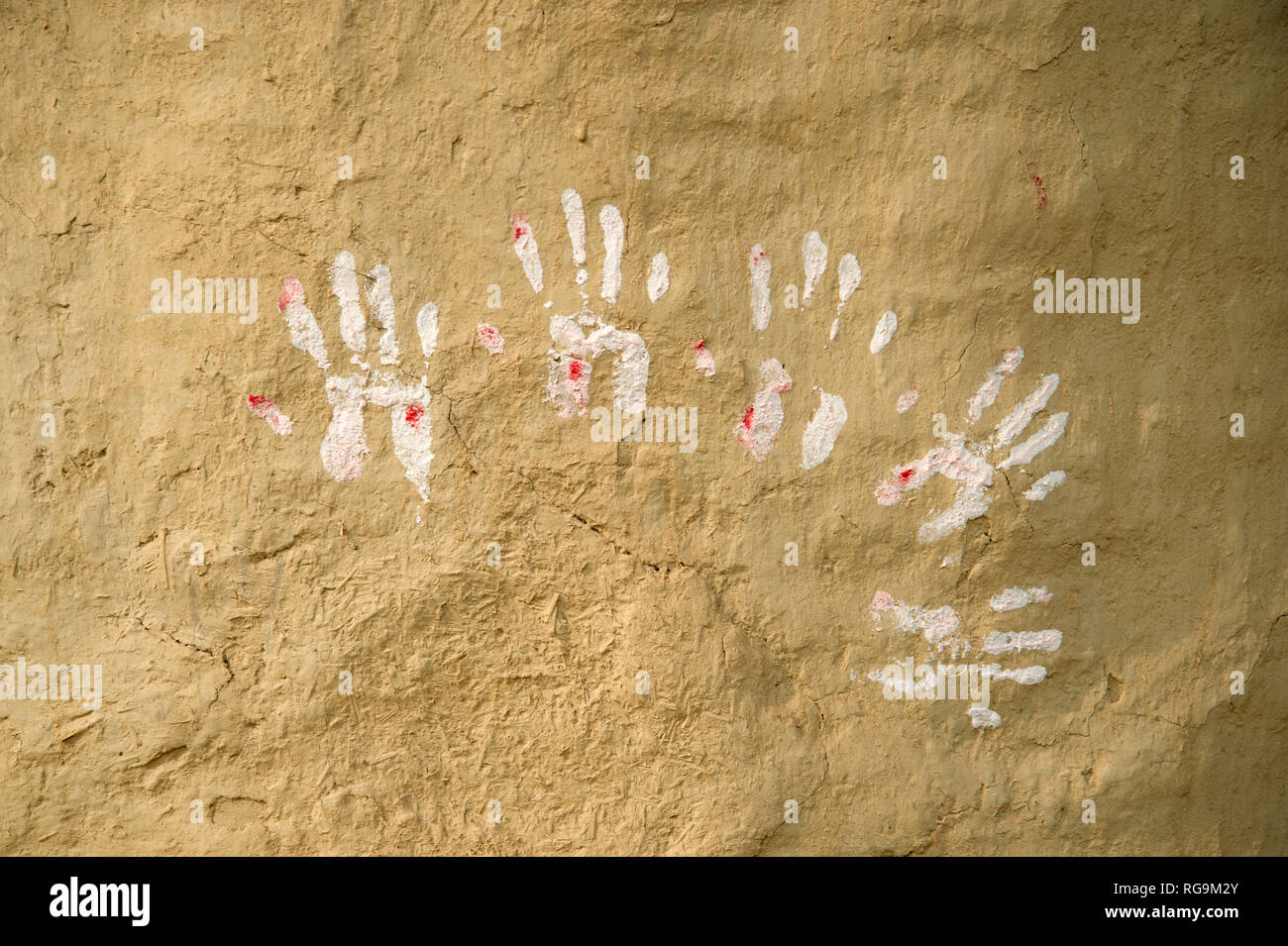 India. Bihar . Katari Middle Village. Handprints bianco su un muro di fango. Foto Stock