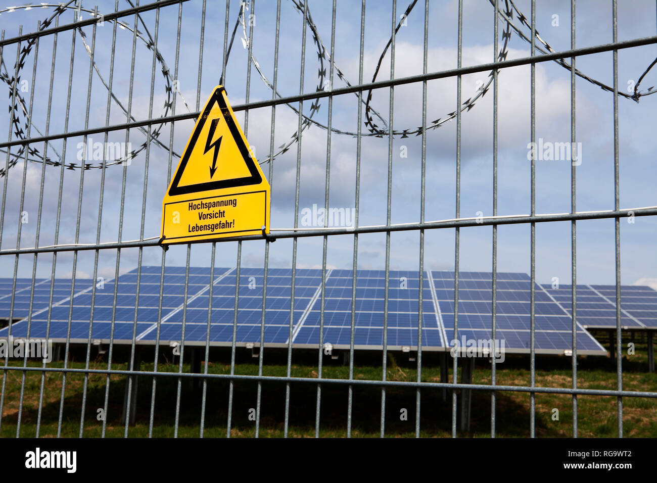 Segnaletica e la recinzione in corrispondenza di uno spazio aperto impianto solare fotovoltaico, Germania, Europa Foto Stock