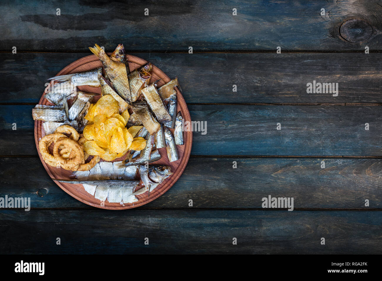 La birra snack set. Salate, pesci secchi, anelli di totano e patate fritte,servita sul tagliere. Foto Stock