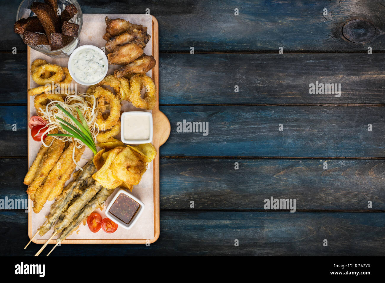 La birra snack set. Set di pesce serviti sul tagliere con la tazze, sullo sfondo di legno. Foto Stock