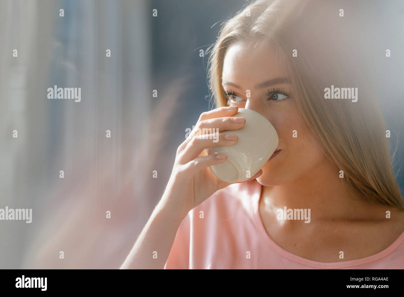 Giovane donna bere tazza di caffè Foto Stock