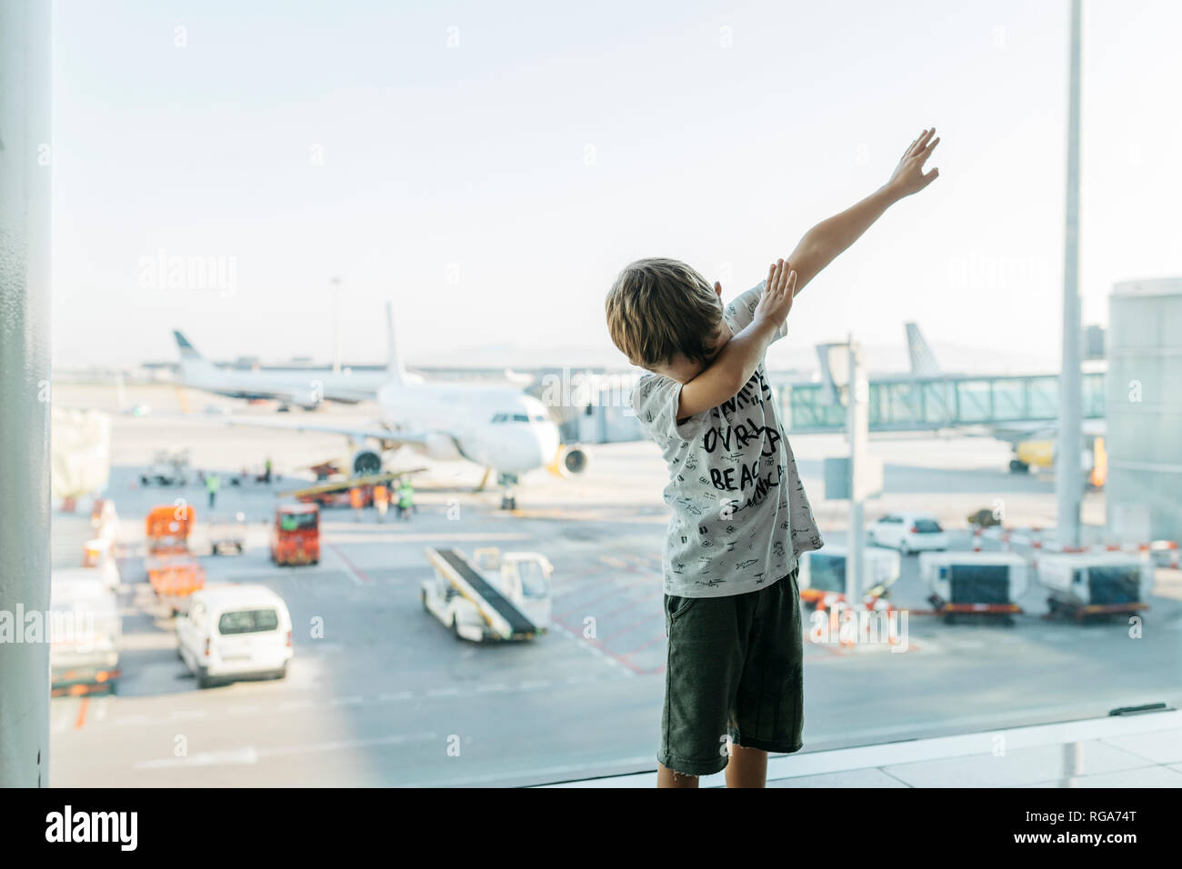 La Spagna, l'aeroporto di Barcellona, ragazzo in zona partenza, fingendo di volare Foto Stock