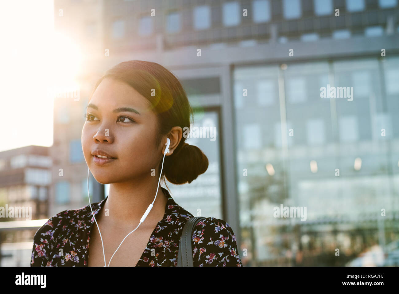 Contenuto imprenditrice asiatici ascoltare musica ad una fermata del bus Foto Stock