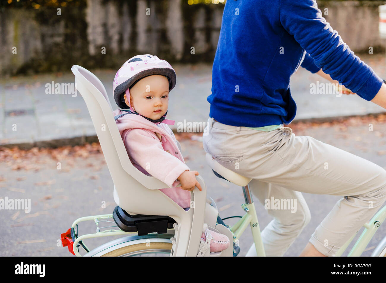 Madre e figlia Bicicletta Equitazione, baby indossando il casco in seduta i bambini del posto di guida Foto Stock