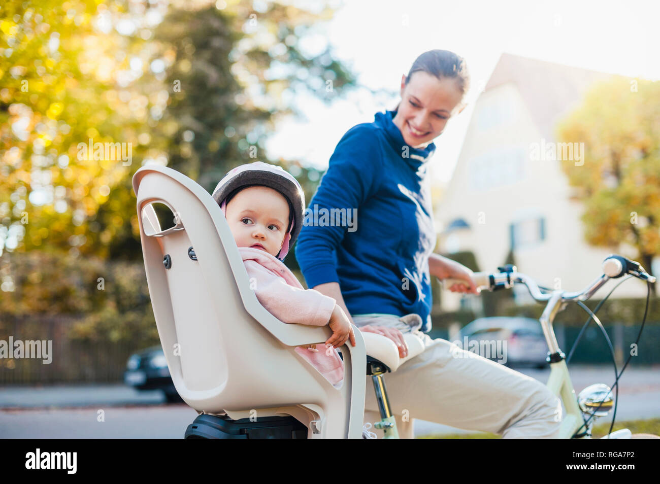 Madre e figlia Bicicletta Equitazione, baby indossando il casco in seduta i bambini del posto di guida Foto Stock