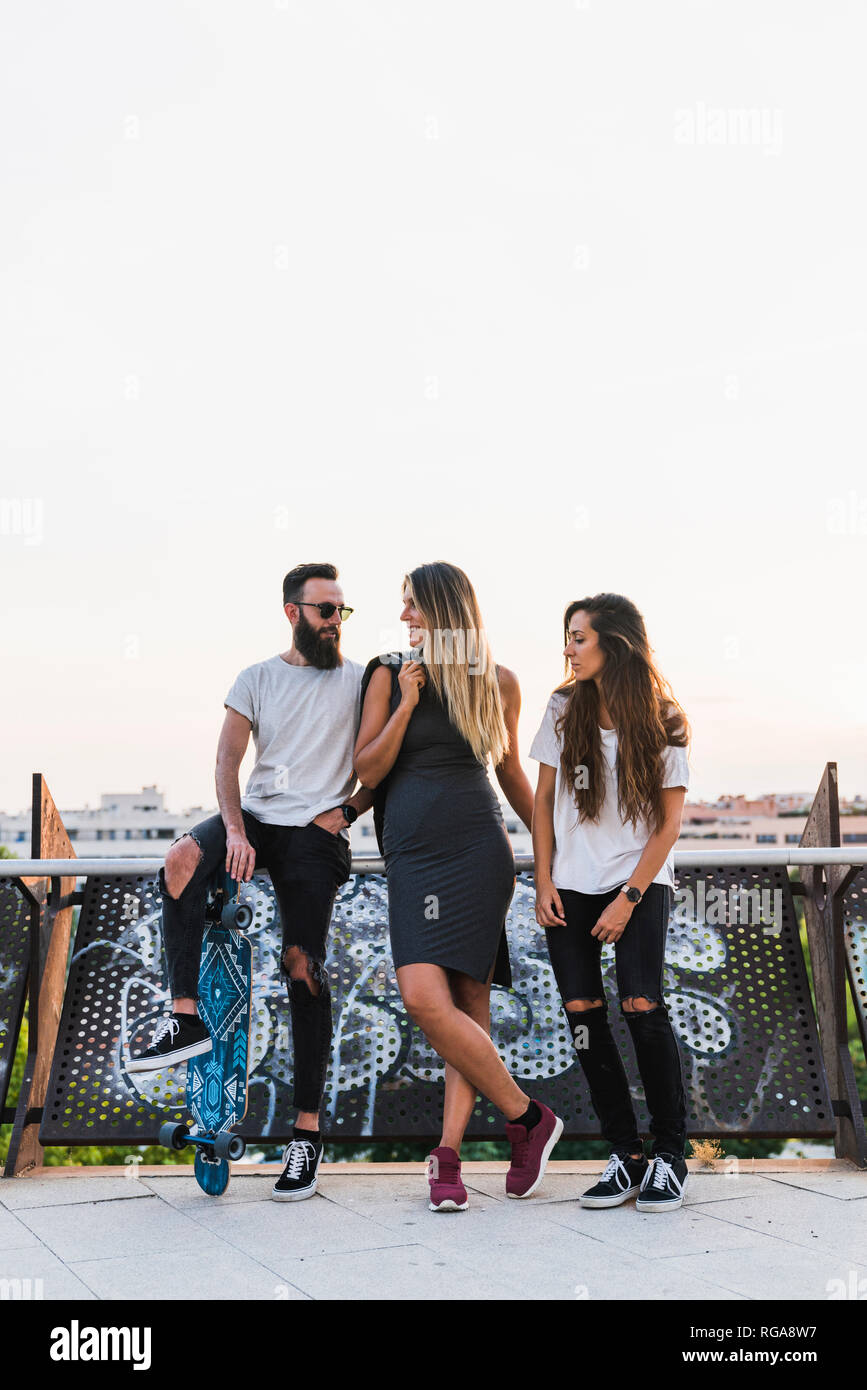 Amici con lo skateboard appendere fuori città Foto Stock