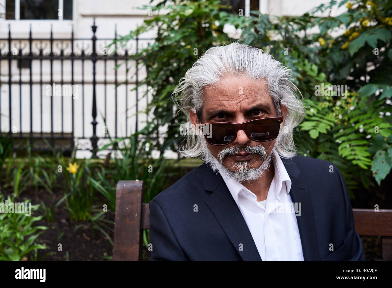 Ritratto di starring imprenditore senior con occhiali da sole Foto Stock