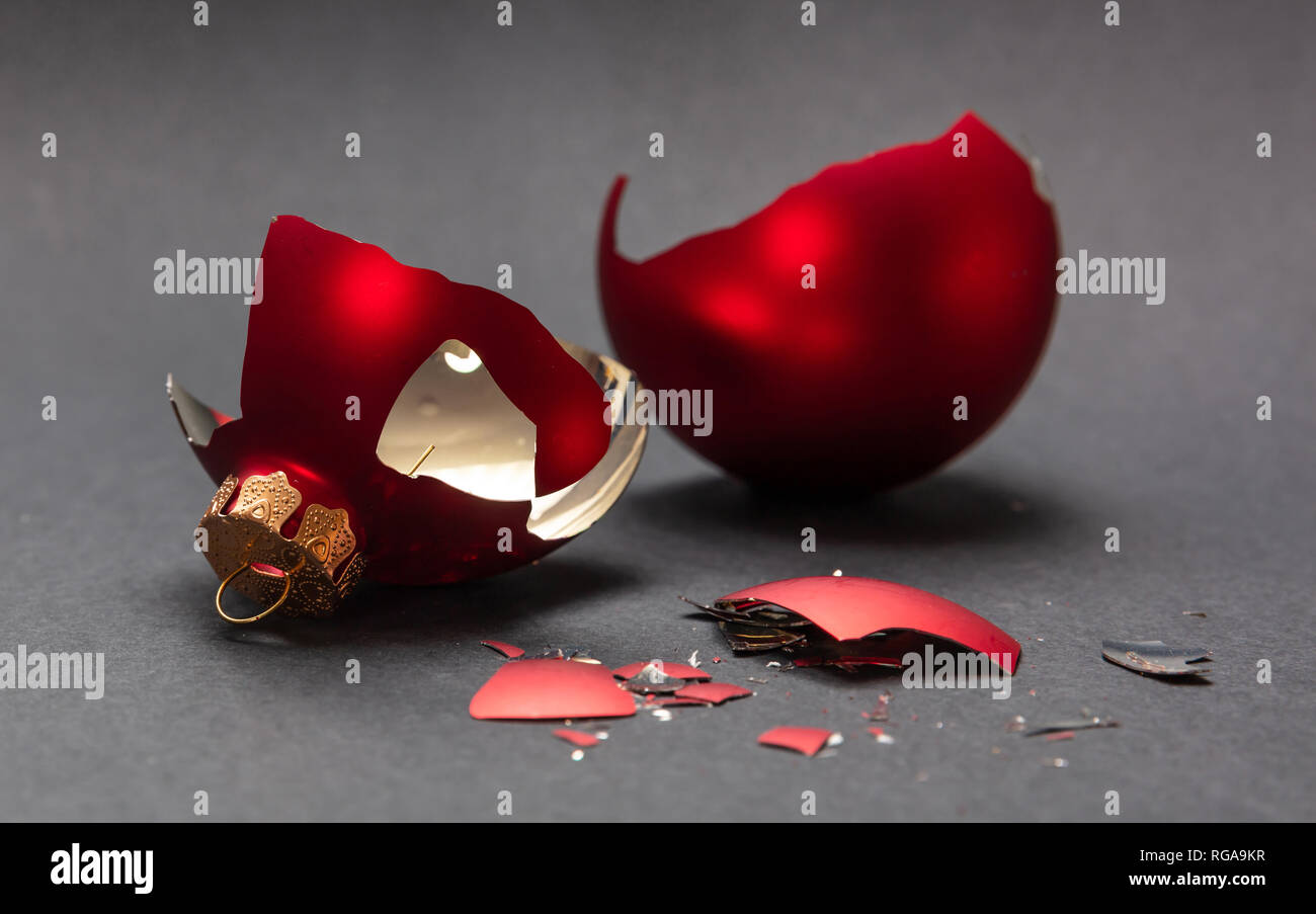 Incidente di natale. Red Pallina natale rotto, sfondo grigio scuro, primo piano Foto Stock