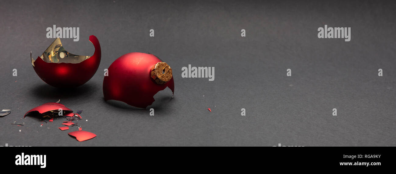 Incidente di natale. Red Pallina natale rotto, sfondo grigio scuro, banner, spazio di copia Foto Stock