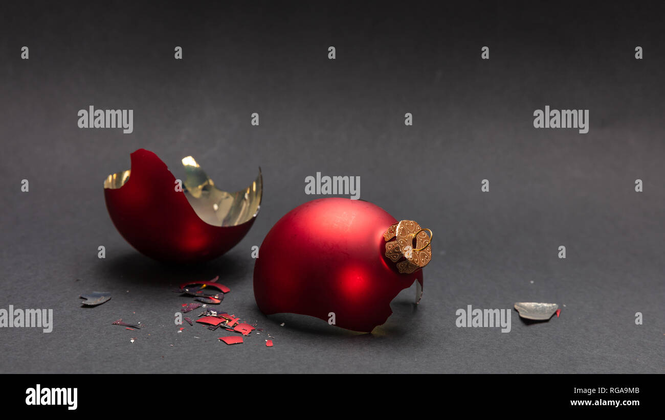 Incidente di natale. Red Pallina natale rotto, sfondo grigio scuro, primo piano Foto Stock