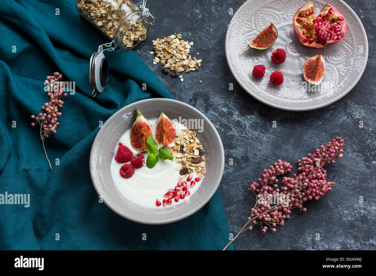 Ciotola di yogurt naturale con frutta muesli, lamponi, fichi e i semi di melograno Foto Stock