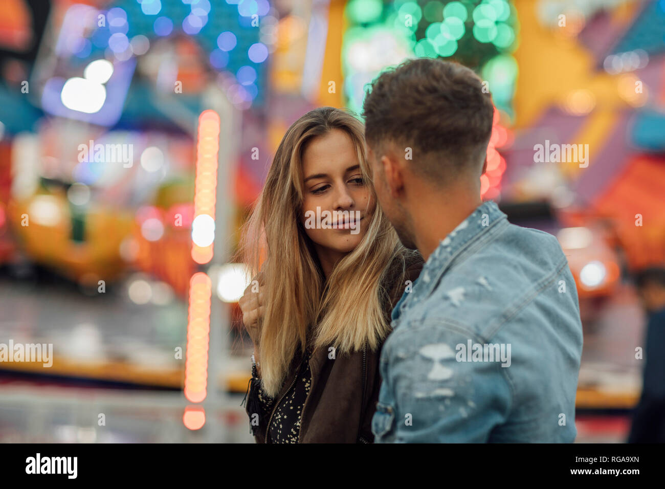 Coppia giovane in amore, abbracciando in un luna park Foto Stock