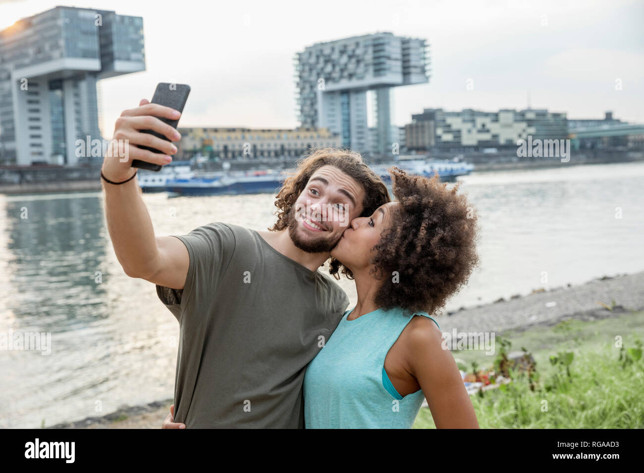 Germania, Colonia, felice coppia prendendo un selfie al Riverside Foto Stock