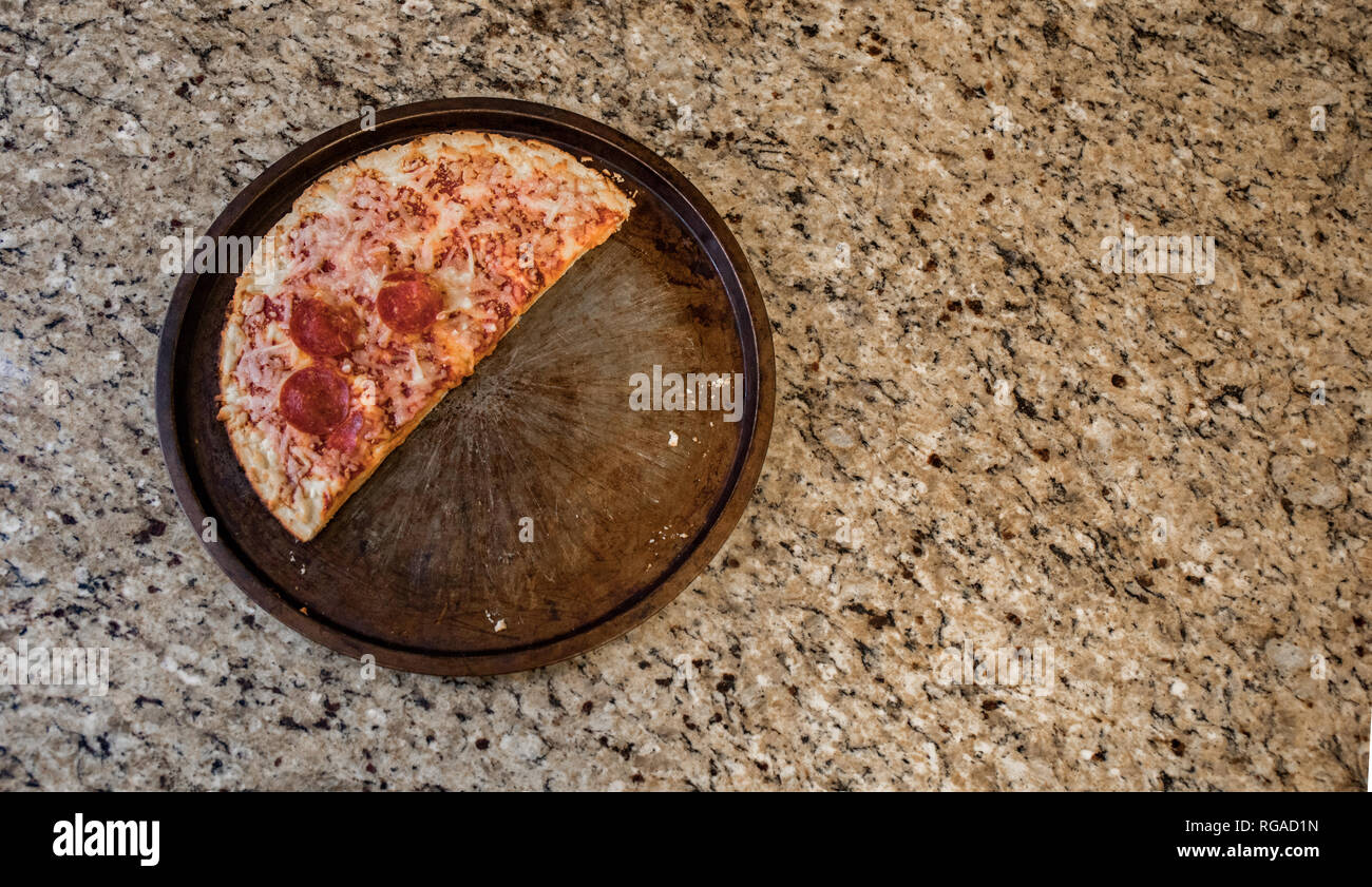 La metà di un retaggio pizza congelata scartato sul bancone. Foto Stock