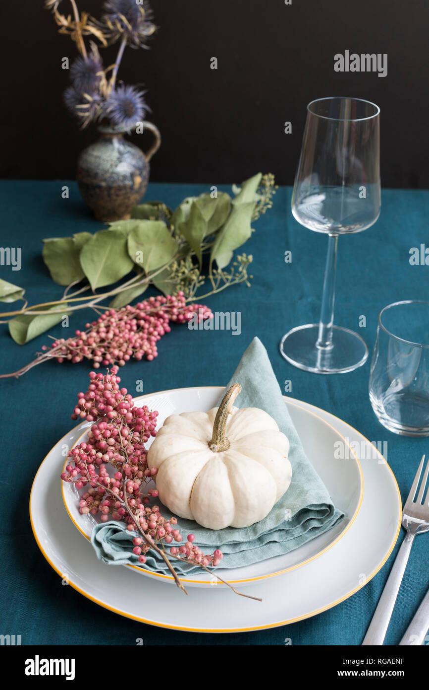 Autunnale di decorazioni per la tavola con bianco zucca decorativa e pepe rosa Foto Stock