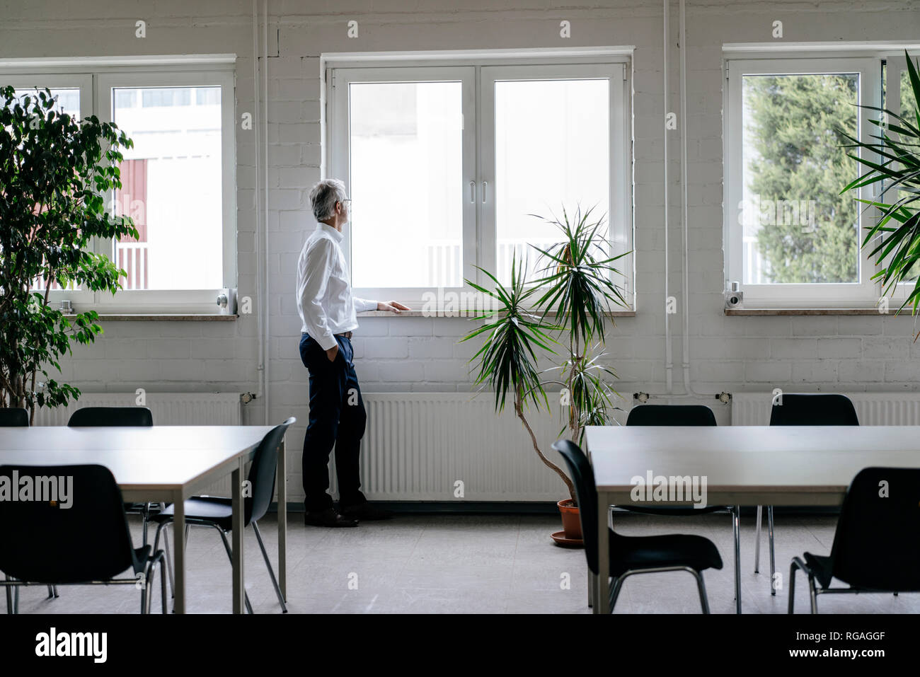 Imprenditore prendendo una pausa, guardando fuori della finestra Foto Stock