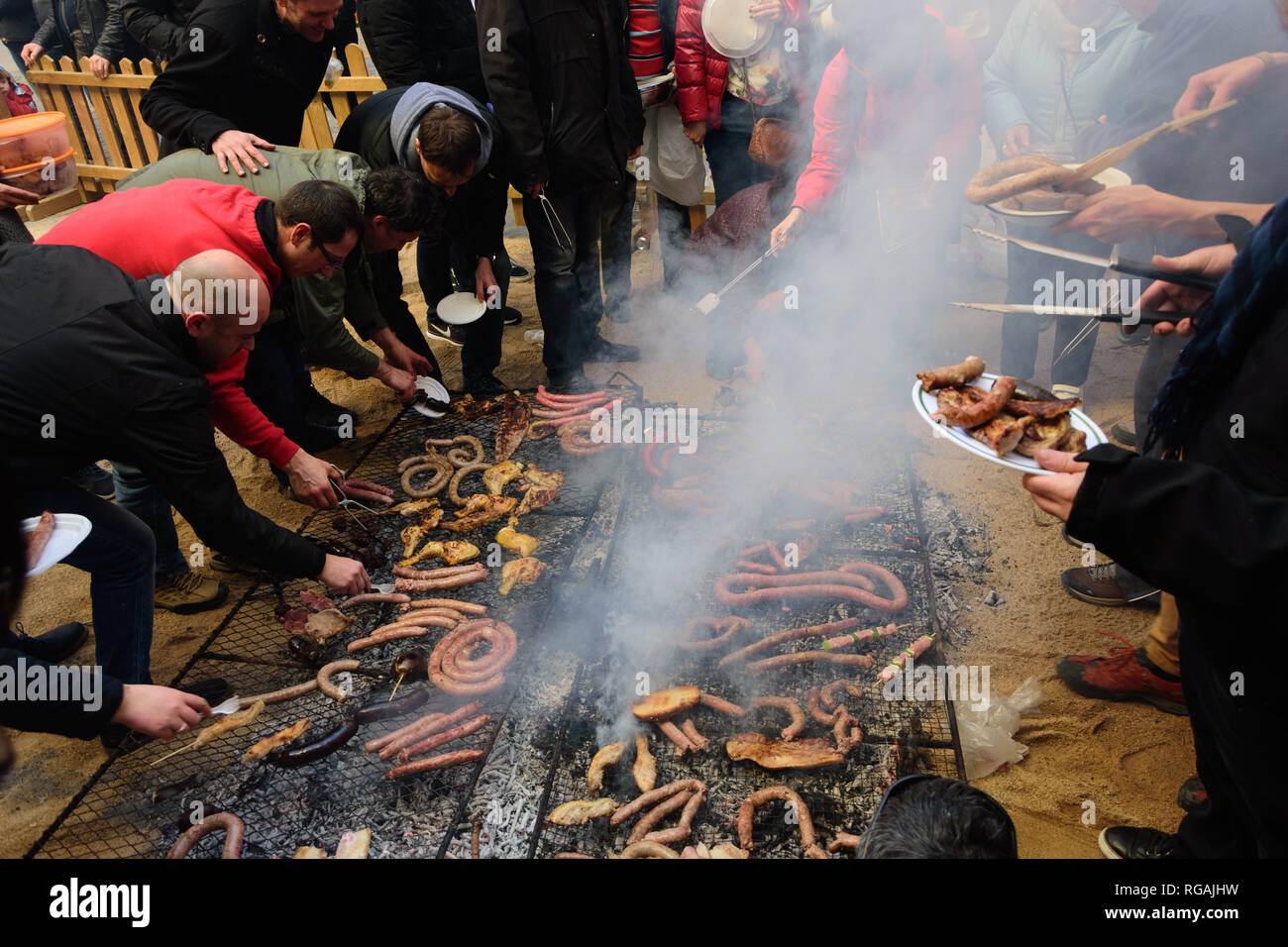 Persone cuocere carne su un grande BBQ a Calçotada in Valls, Catalogna, Spagna. Foto Stock