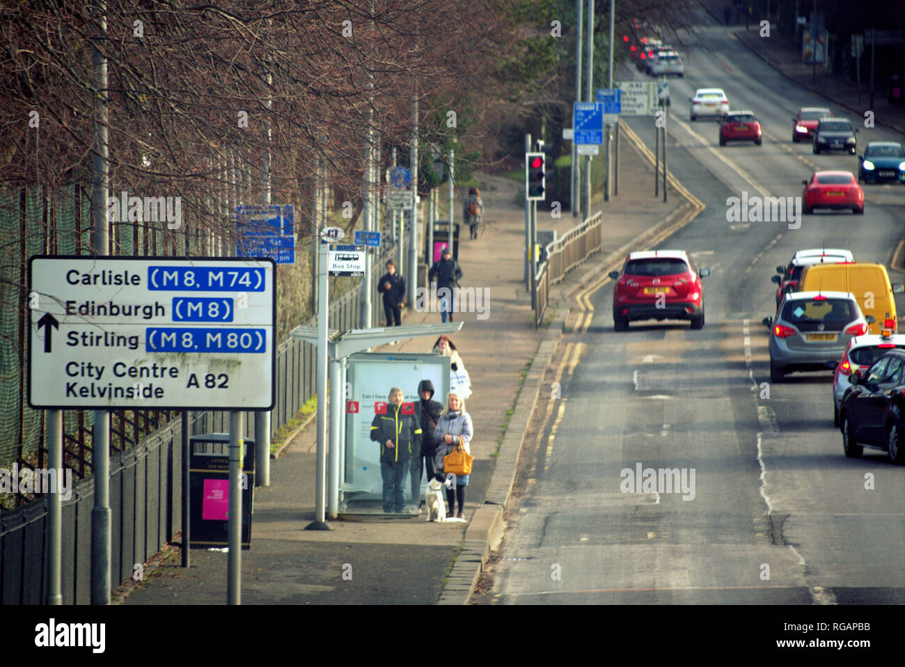 Persone in attesa a un bus top con traffico pesante su Great Western Road, A82, Glasgow, Scotland, Regno Unito Foto Stock