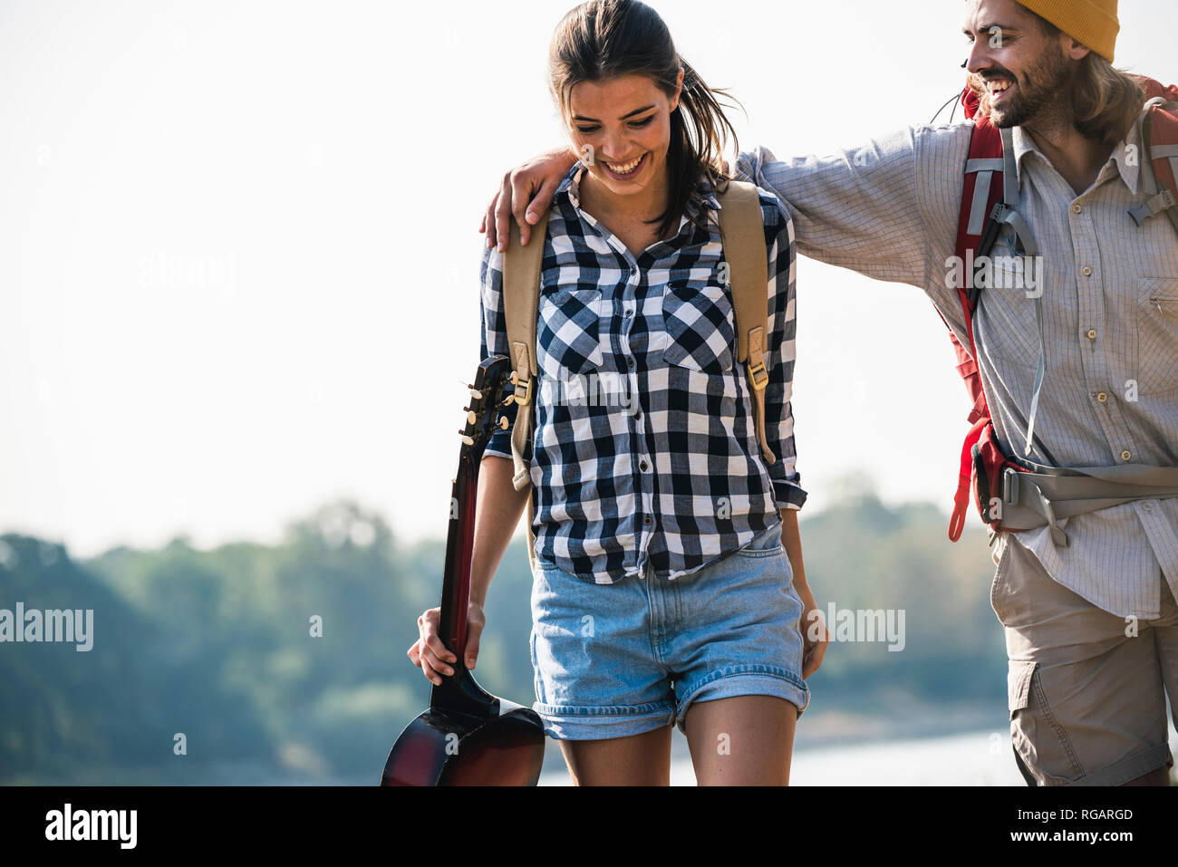 Felice coppia giovane con zaini e chitarra all'aperto Foto Stock