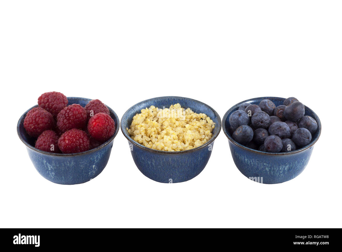 Piccole ciotole di spuntini sani: Lamponi, quinoa cotta e mirtilli ritagliati su sfondo bianco Foto Stock