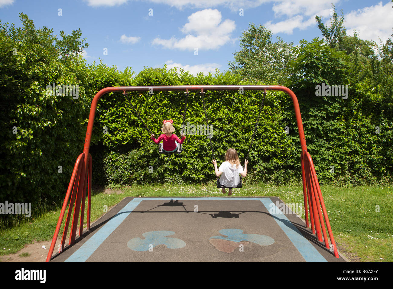 Due ragazze caucasion giocando su oscilla in un parco in un parco giochi Foto Stock