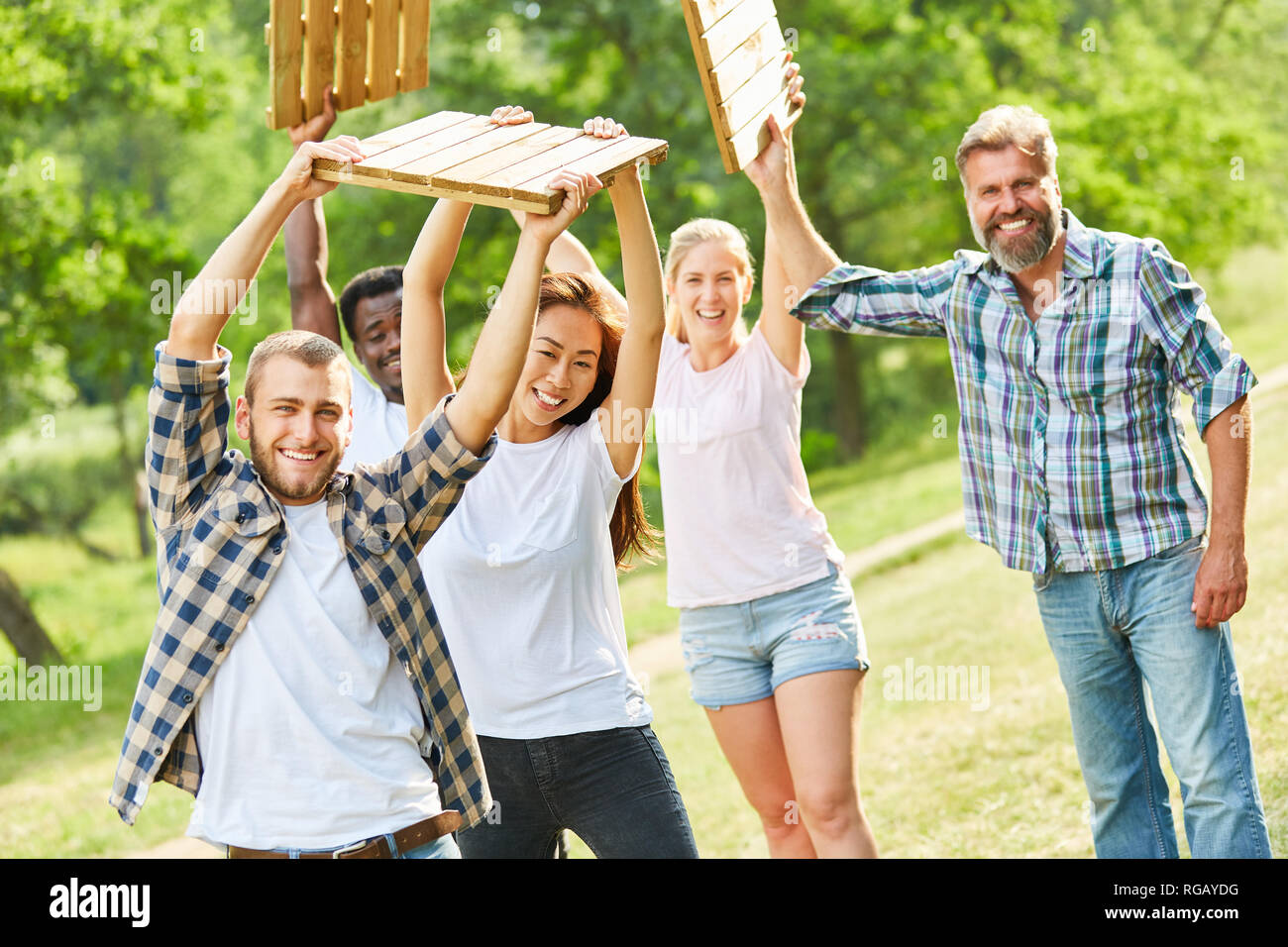 Giovane team facendo allenamento di fitness o di un teambuilding gioco con piastrelle in legno Foto Stock