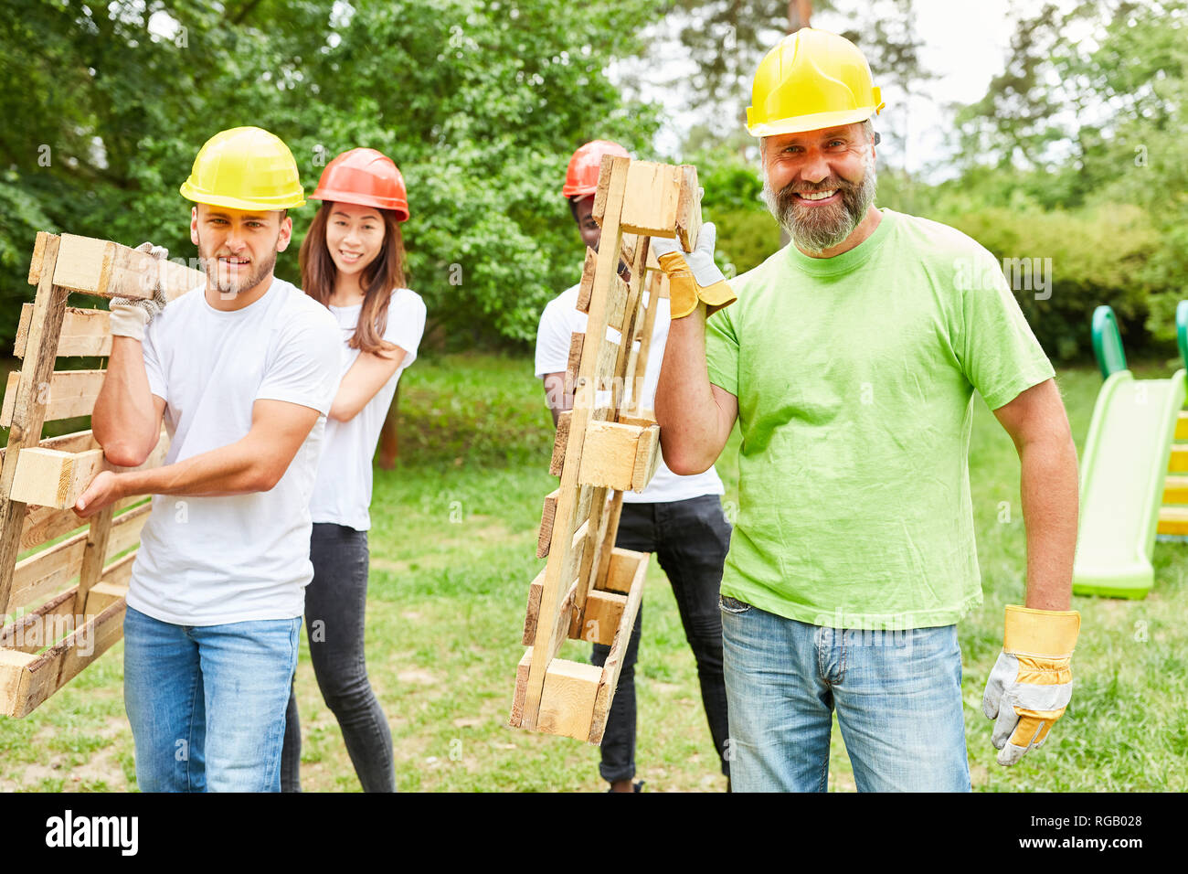 Operaio edile team conduce insieme il trasporto di pallet attraverso un parco Foto Stock