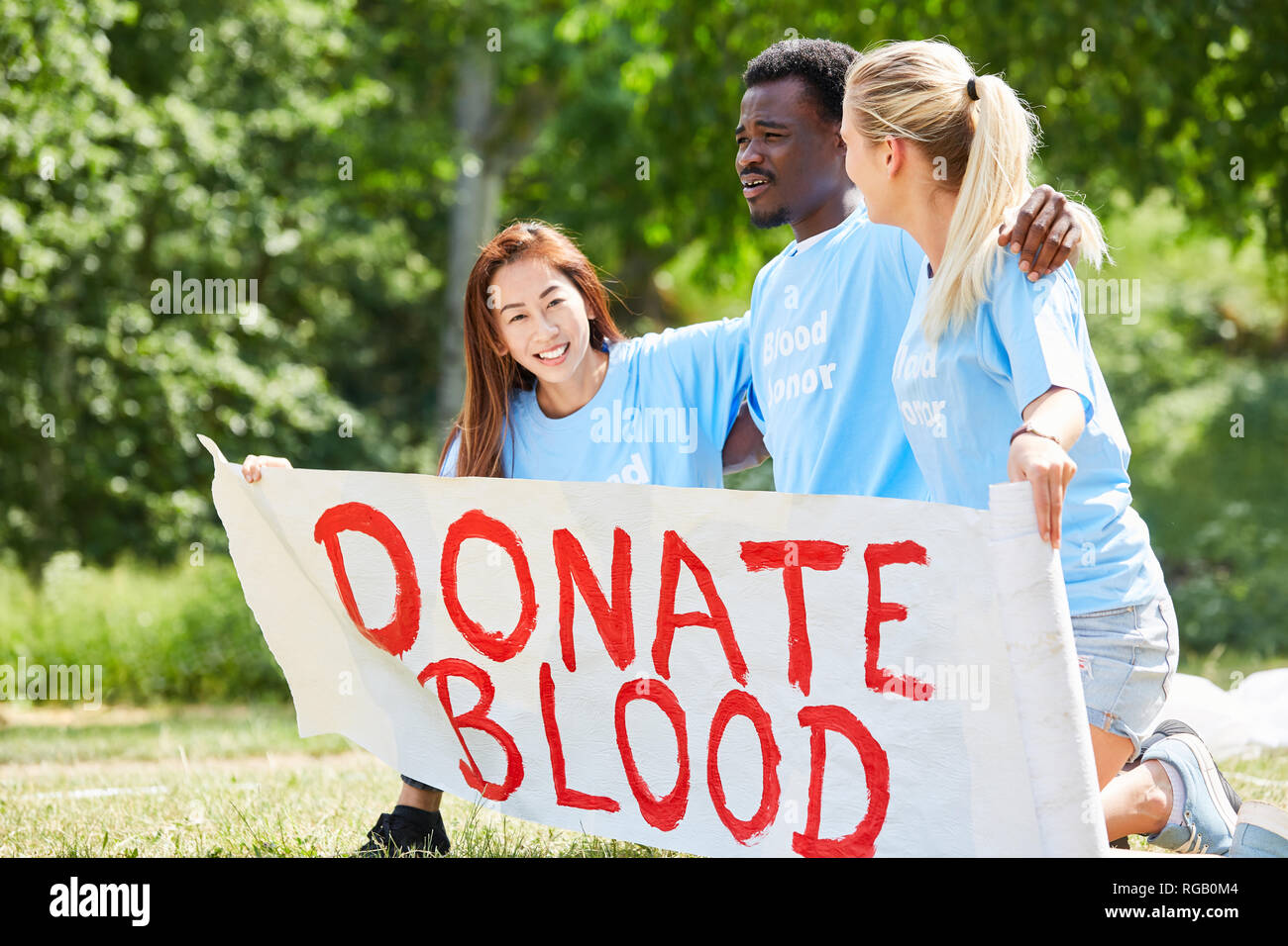 I volontari del volontario campagna per la donazione di sangue con il testo donare sangue Foto Stock