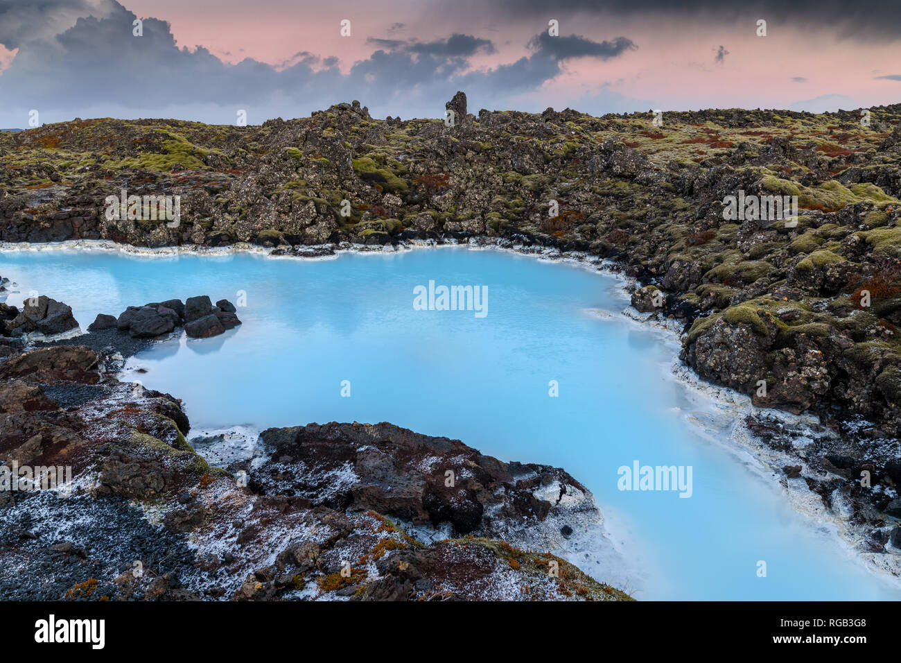 Drammatico paesaggio di un bellissimo terreno vulcanico con nere rocce vulcaniche e acqua turchese a laguna blu nei pressi di Grindavik nella penisola di Reykjanes Foto Stock