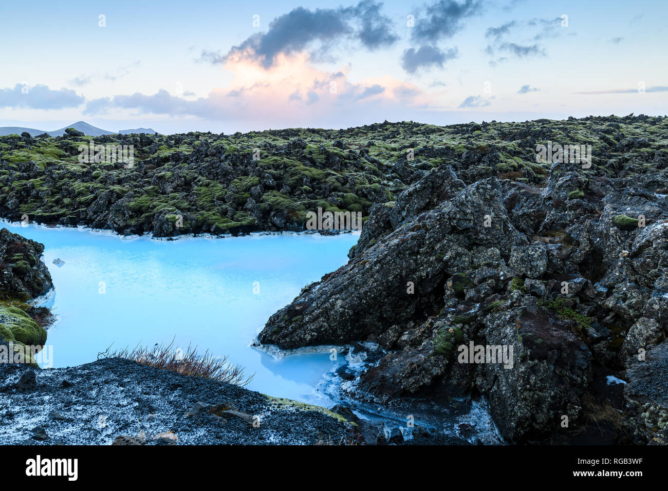 Drammatico paesaggio di un bellissimo terreno vulcanico con nere rocce vulcaniche e acqua turchese a laguna blu nei pressi di Grindavik nella penisola di Reykjanes Foto Stock