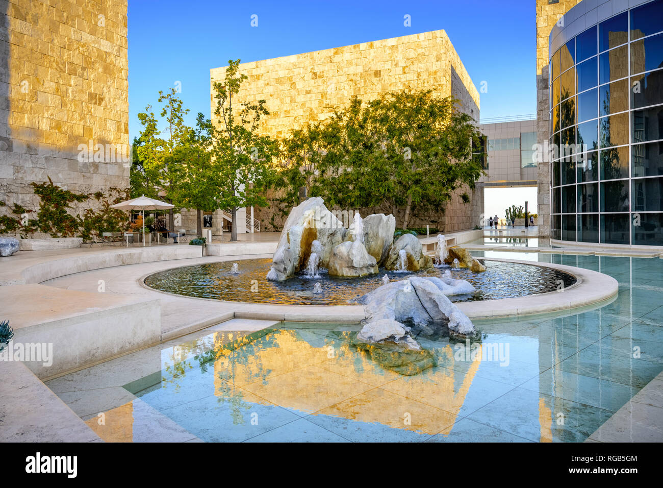 Giugno 8, 2018 Los Angeles / CA / STATI UNITI D'AMERICA - fontana d'acqua nel cortile del museo del Getty Center al tramonto; travertino parete coperta, illuminata da th Foto Stock