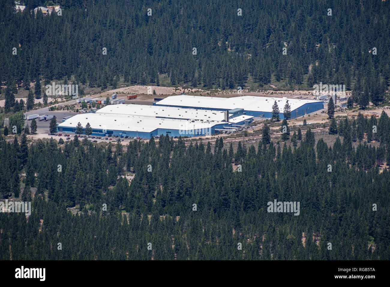 Giugno 25, 2018 Weed / CA / STATI UNITI D'AMERICA - Vista aerea di Crystal Geyser Primavera alpina acqua da CG Roxane facility, circondato da foreste Foto Stock
