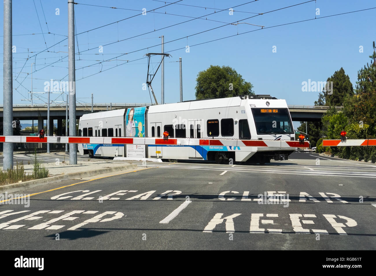 Agosto 2, 2018 Mountain View / CA / STATI UNITI D'AMERICA - In attesa di una barriera per un VTA treno per passare nella parte sud di San Francisco Bay; VTA Light Rail è un sistema che serve Foto Stock