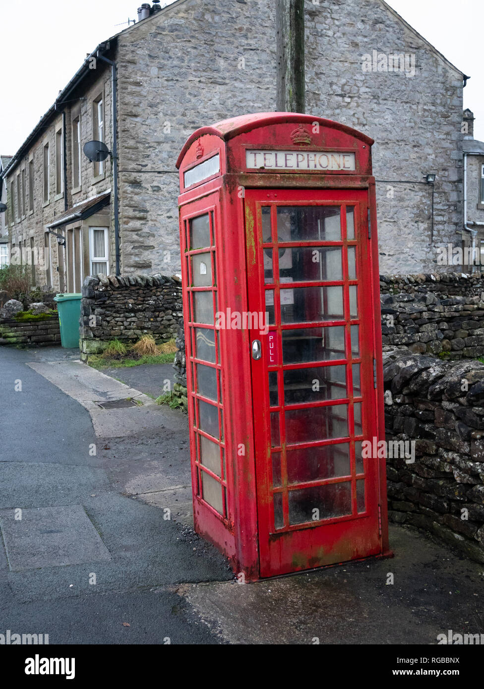 Un vecchio telefono rosso scatola nel villaggio di Horton in Ribblesdale nel Yorkshire Dales. Foto Stock