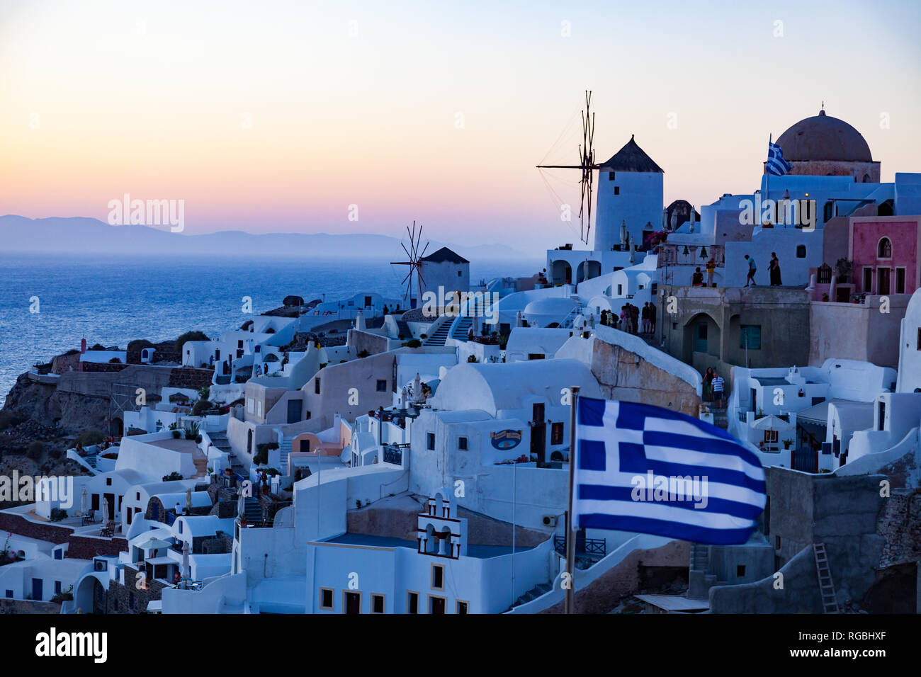 Vista del villaggio di Oia con mulini a vento al tramonto, Santorini, Grecia, molto popolare di battello da crociera sosta nel Mare Mediterraneo Foto Stock