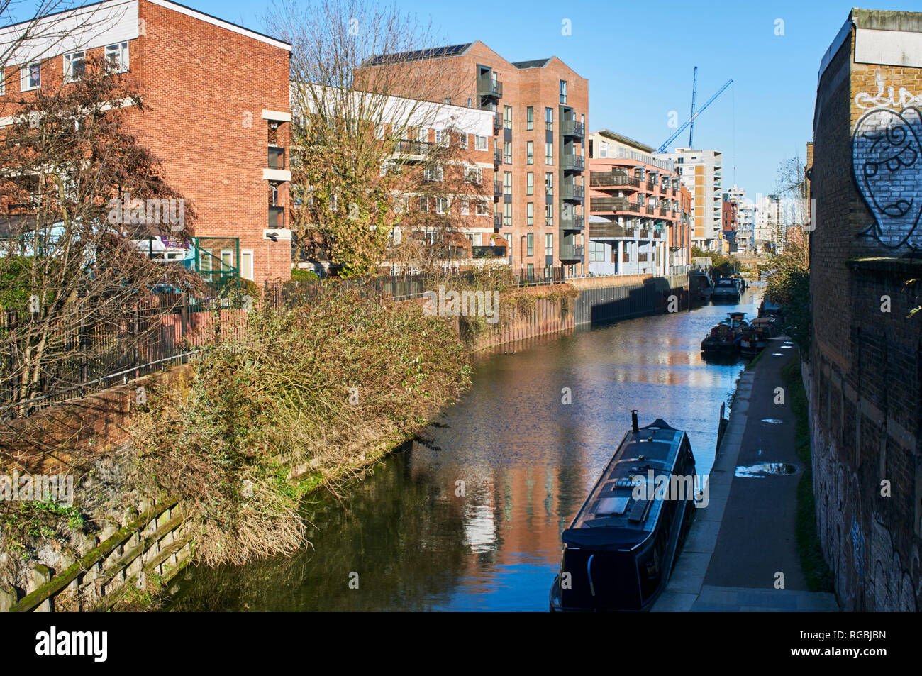 Nuovi appartamenti lungo la sponda del Regents Canal a Limehouse, East London UK, visto dalla strada commerciale Foto Stock