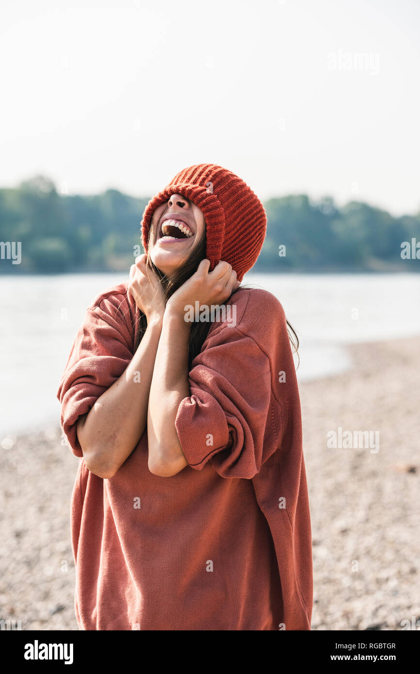 Spensierato giovane donna indossa wooly hat al Riverside Foto Stock