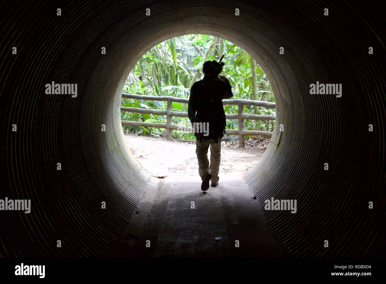 Silhouette di un uomo proveniente da un tunnel scuro emergente nella luce Foto Stock