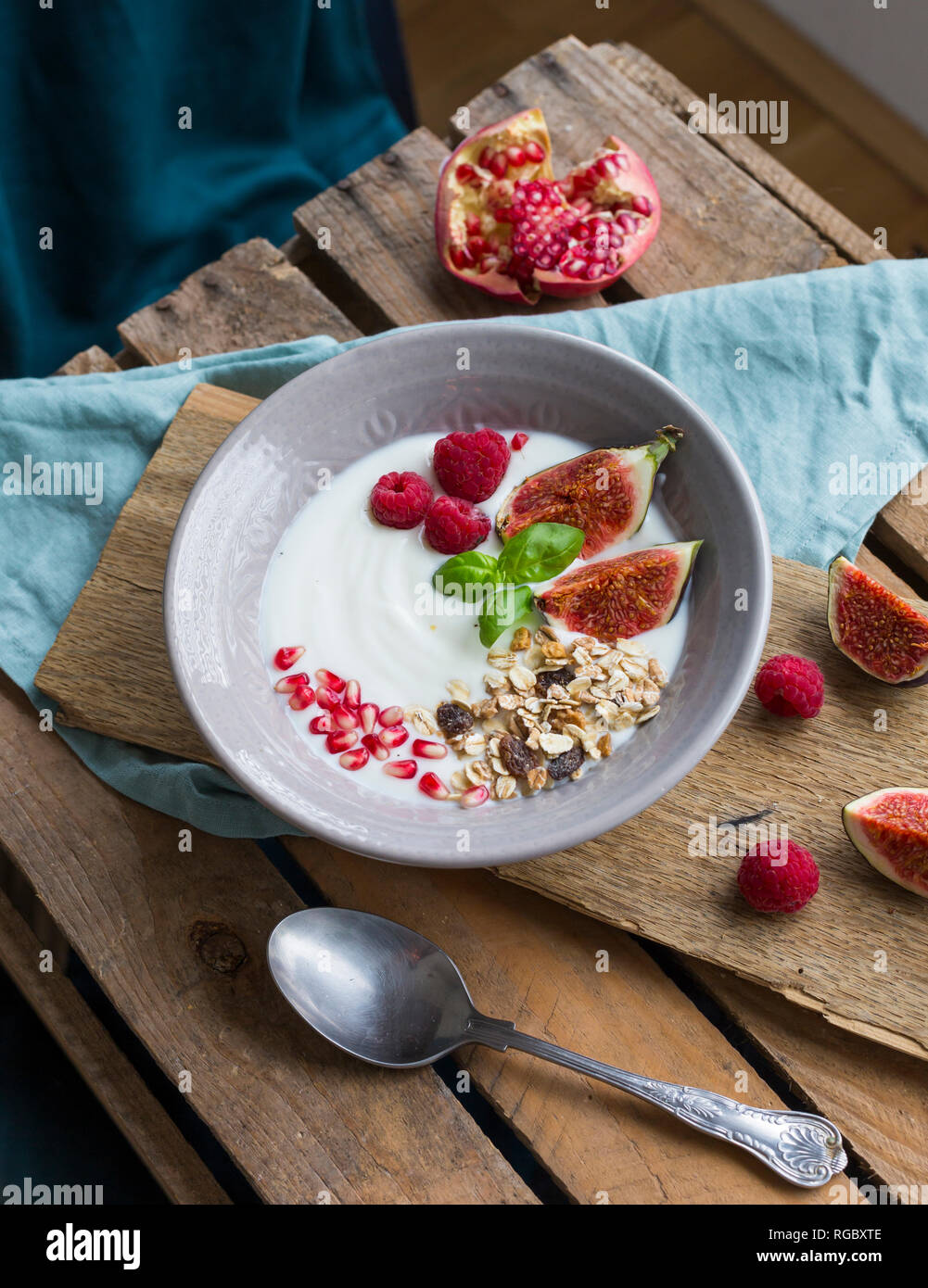 Ciotola di yogurt naturale con frutta muesli, lamponi, fichi e i semi di melograno Foto Stock