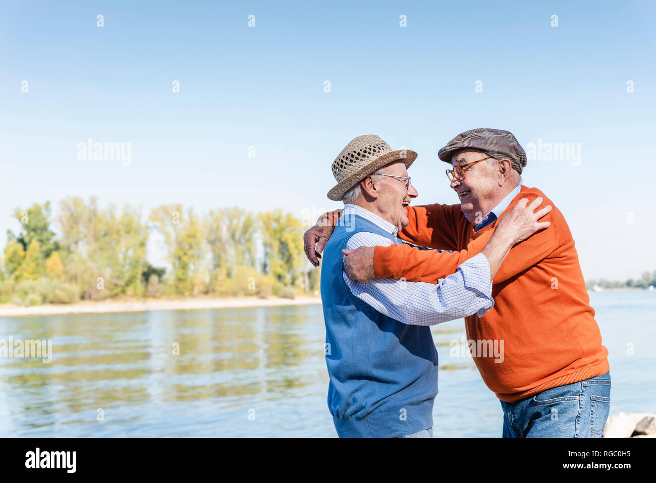 Due vecchi amici ricongiungimento al Riverside, abbracciando ogni altra felicemente Foto Stock