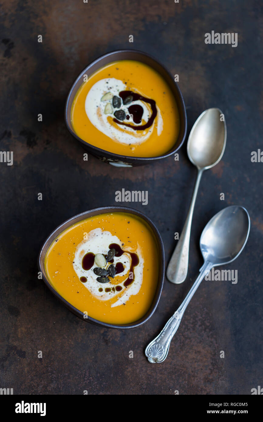 Due ciotole in casa di Hokkaido zuppa di zucca farcita con crema di zucca, semi e olio di semi di zucca Foto Stock