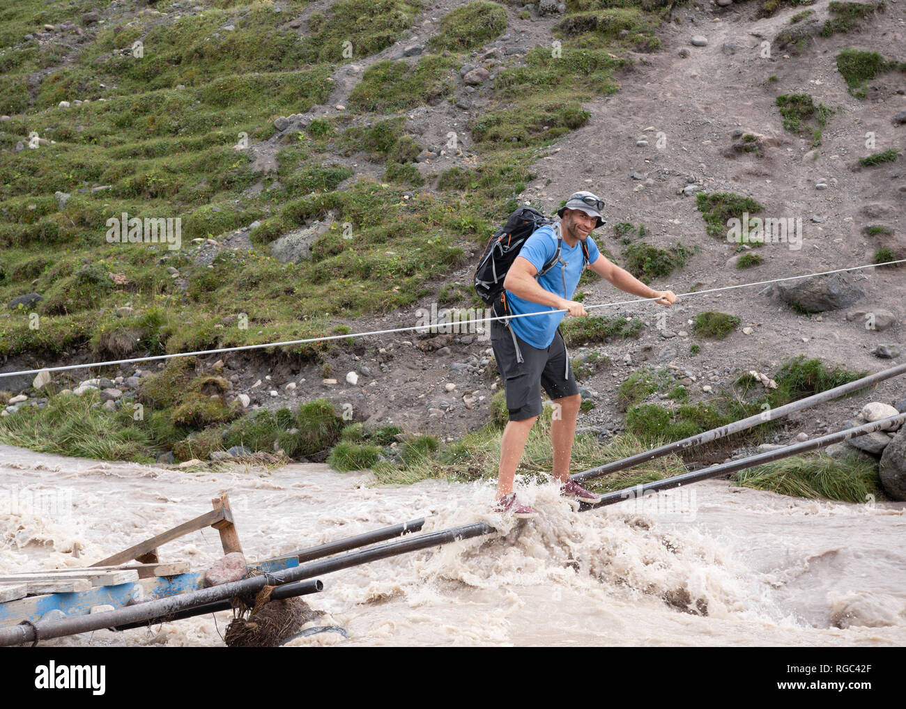 La Russia, il Caucaso, alpinista Varcando il fiume in Alta Valle Baksan Foto Stock