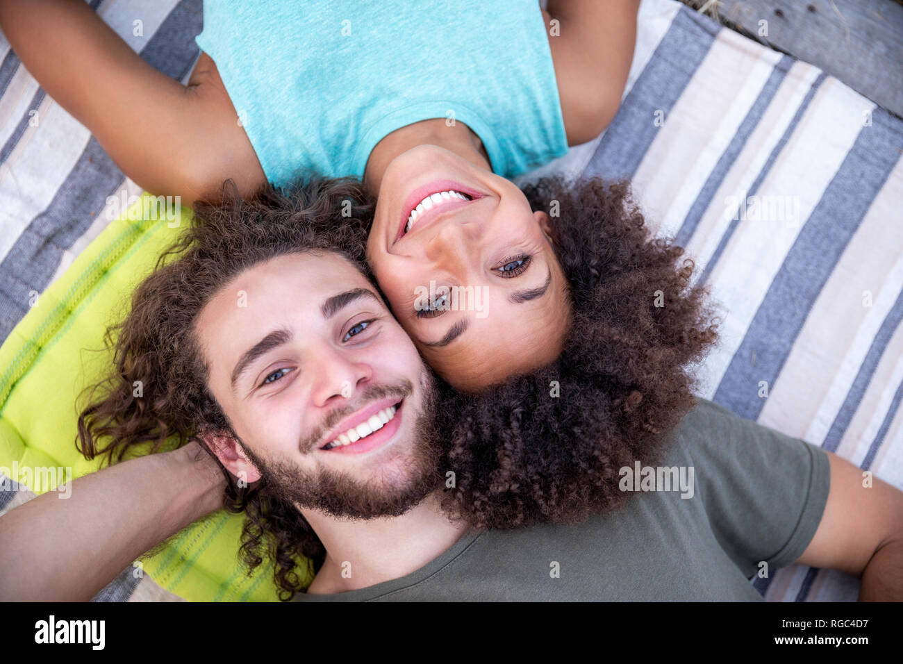 Ritratto di felice coppia giacendo su una coperta all'aperto Foto Stock