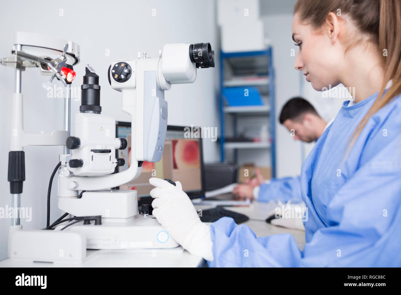 Tecnico di laboratorio lavora con microscopio in laboratorio Foto Stock