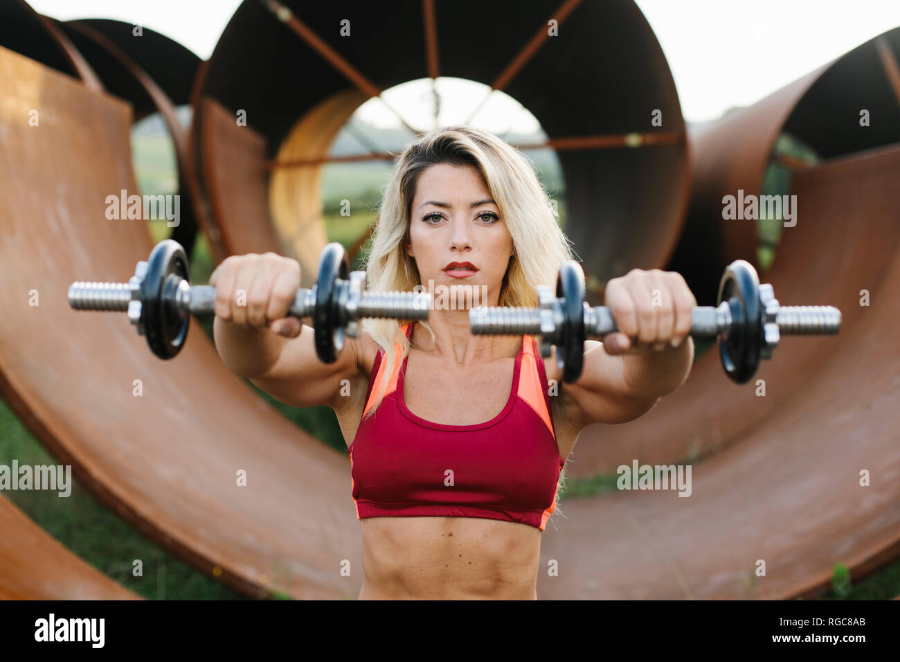 Athletic donna facendo peso allenamento presso il sito industriale Foto Stock